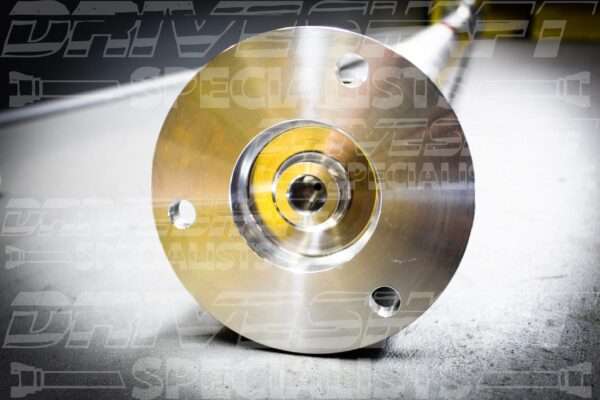 Aluminum drive shaft end with polished finish, featuring a central hole and multiple bolt holes for installation.