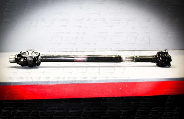 Front and rear 1350 series driveshaft for 2018+ Jeep JL, featuring solid black tubing, U-joints, and pinion flanges.